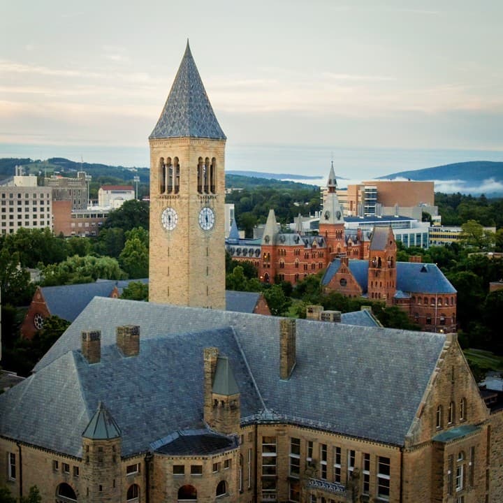 Aerial view of Cornell University’s McGraw Tower and Uris Library overlooking the Ithaca campus and Cayuga Lake in the distance.