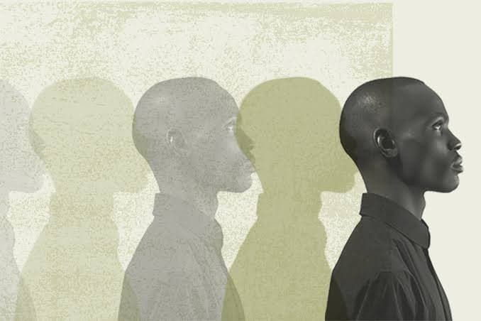 A row of overlapping profile silhouettes fading from pale to dark, representing one figure coming into sharp focus.